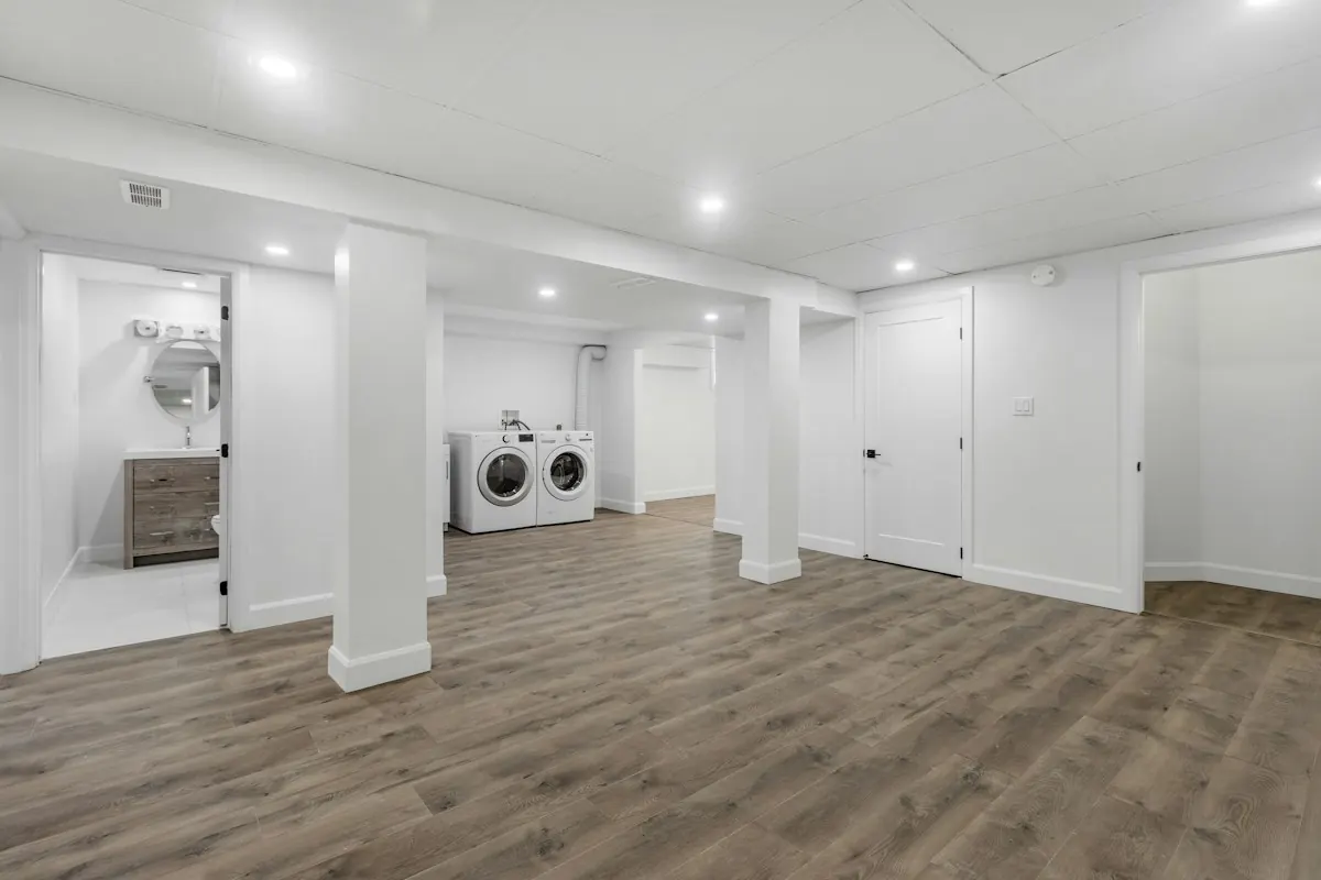Clean, finished lower-level room with laundry area